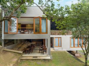 Casa con porche con mesa y sillas en Birds Park Polgahawela en Egalla