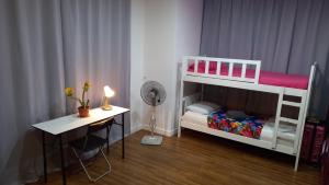CUSHY DORM at KLCC في كوالالمبور: غرفة صغيرة مع سرير بطابقين ومكتب