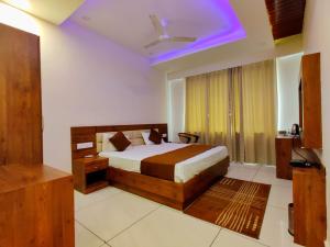 a bedroom with a bed and a ceiling fan at Hotel Divine Residency by VARSHRI in Haridwār +18 photos
