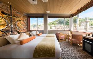 una camera da letto con un letto e una bicicletta appesa al muro di HOTEL BEACON ONOMICHI a Onomichi