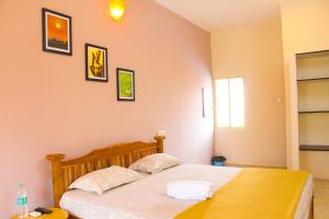 um quarto com uma cama com duas almofadas em Dwaraka Guest House em Tiruvannamalai