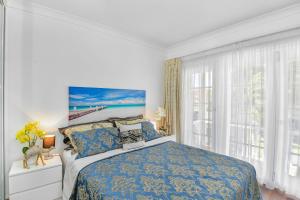 a bedroom with a bed and a large window at Waterfront Entertainers Haven in Toukley