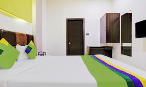 a bedroom with a white bed with a colorful blanket at Treebo Trend Prime Grand, Andheri in Mumbai