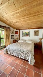 a bed in a bedroom with a wooden ceiling at Cabaña en la Mesa de los Santos in Pescadero