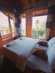 a bedroom with two beds and a large window at Green Nature Paradise Ella in Ella