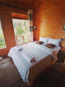 Schlafzimmer mit einem großen weißen Bett und einem Fenster in der Unterkunft Green Nature Paradise Ella in Ella