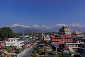 una ciudad con edificios y montañas en el fondo en Hotel Sandalwood en Pokhara