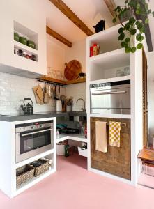 een keuken met witte kasten en een roze vloer bij Guesthouse Rotterdam, tinyhouse nearby Kralingen in Rotterdam