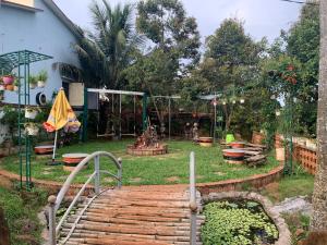 um jardim com um parque infantil com um caminho de madeira em Gia lai Homestay Phương My em Plây Ku
