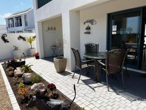 a patio with a table and chairs on a house at Clam Lagoon in Langebaan