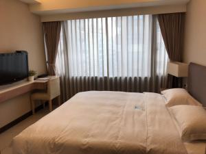 Tempat tidur dalam kamar di AJ Residence 安捷國際公寓酒店