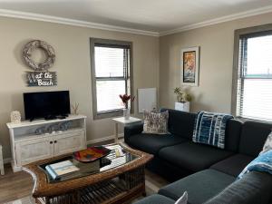 a living room with a couch and a tv at Clam Lagoon in Langebaan