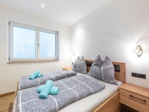 1 Schlafzimmer mit 2 Betten und blauen Kissen in der Unterkunft Group apartment in Piesendorf with barbecue in Piesendorf