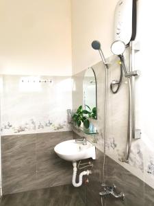 a bathroom with a sink and a shower at NHỚ House II in Da Lat