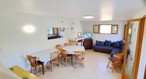 sala de estar con mesa, sillas y sofá en Quiet and Nature Holiday Home on the Cote dAzur, en Le Bar-sur-Loup