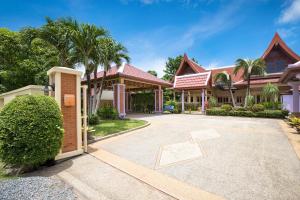 una casa con cortile e palme di Beautiful 5BR Villa Felicity, Pool & Garden, near Naiharn a Rawai Beach