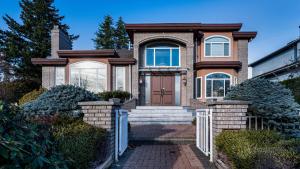 una casa in mattoni con porta marrone e scale di 温西区豪华别墅附有按摩浴缸钢琴，接近机场downtown a Vancouver