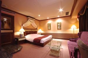 um quarto de hotel com uma cama e um sofá em Hotel Pharaoh-Adult Only em Sapporo
