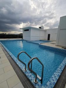 a swimming pool with two metal hand rails in a building at Hotel Mutiara in Gua Musang
