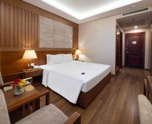 Postel nebo postele na pokoji v ubytování Eden Star Saigon Hotel