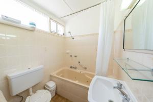 een badkamer met een bad, een toilet en een wastafel bij Halfway Motel in Eden