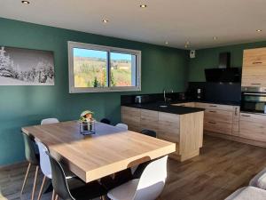 a kitchen with a wooden table with chairs and a kitchen with a counter at La maison d'Elodie in Foncine-le-Haut