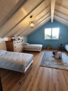 um quarto com 2 camas e um tecto de madeira em La maison d'Elodie em Foncine-le-Haut