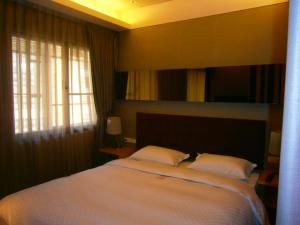 Postel nebo postele na pokoji v ubytování AJ Residence 安捷國際公寓酒店