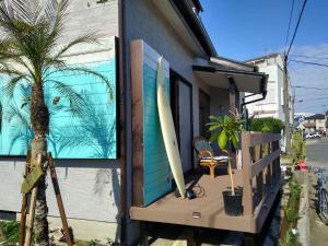 a house with two surfboards sitting on a porch at シーカレント　ゆな　CHIKURA in Chikura