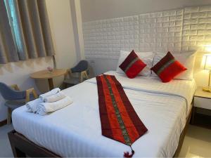 a hotel room with a bed with towels on it at DE ROSE Hotel Chiang Mai in Chiang Mai