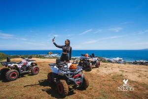 a woman standing in front of four atvs and a woman at Nest Resort in Pagudpud
