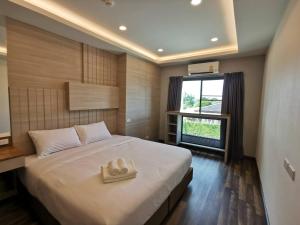 Ban Nong ChaengにあるPremiercondo Chonburi พรีเมียร์คอนโด ชลบุรีのベッドルーム1室(ベッド1台、タオル2枚付)