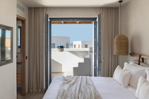 a bedroom with a bed and a large window at Phos Milos in Pollonia