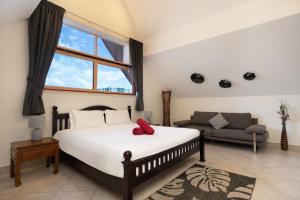una camera da letto con un letto grande e un divano di Beautiful 5BR Villa Felicity, Pool & Garden, near Naiharn a Rawai Beach Altre 23 foto