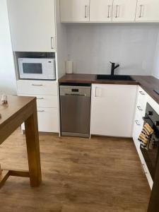 a kitchen with white cabinets and a sink at Fabulous Sea Views in the heart of Surfers in Gold Coast