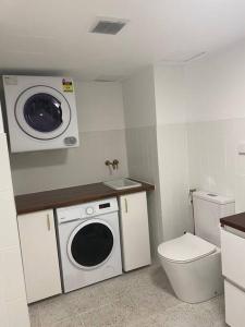 a small bathroom with a washing machine and a toilet at Fabulous Sea Views in the heart of Surfers in Gold Coast