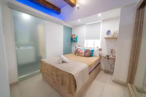 a small bedroom with a bed and a shower at JBO- Joette's Bliss Oasis in Valletta
