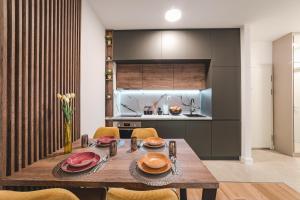 a dining room with a wooden table and a kitchen at Zafiro Residence in Budva