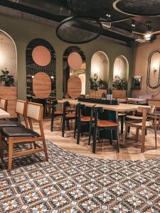 een eetkamer met tafels en stoelen en een tapijt bij City Heez Apartman in Tuzla