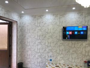 a flat screen tv on a wall in a room at Дом Отель Бадамзар in Tashkent