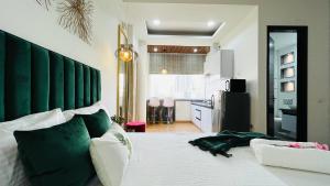 a bedroom with a large white bed with a green headboard at Olive Service Apartments - City Centre Noida in Noida