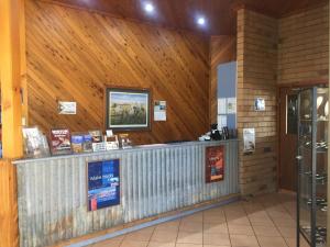 a ticket counter in a building with wooden walls at Boulder Opal Motor Inn in Winton