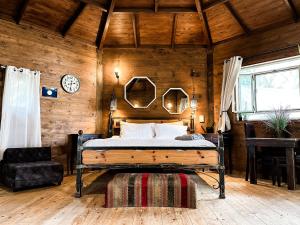 a bedroom with a bed in a wooden wall at Crimson View in Moshav Ramot