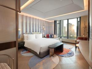 廈門市にあるHotel Indigo Xiamen Haicang, an IHG Hotel-First Day Free Mini Barのベッドと大きな窓が備わるホテルルームです。