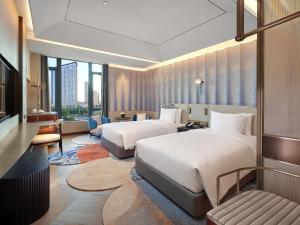 廈門市にあるHotel Indigo Xiamen Haicang, an IHG Hotel-First Day Free Mini Barのベッド2台と大きな窓が備わるホテルルームです。