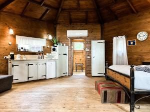 a kitchen with white appliances in a wooden cabin at Crimson View in Moshav Ramot