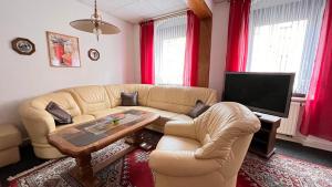 ein Wohnzimmer mit einem Sofa und einem TV in der Unterkunft Ferienwohnung NEUMANN a.d. Porzellan-Manufaktur in Meißen