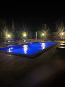 a swimming pool at night with blue water at Riad les trois merveilles in Essaouira