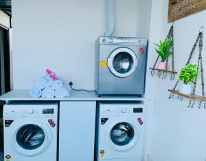 BluO Studio Noida - BathTub, Gym, Balcony, Garden في نويدا: وجود غسالتين وغسالة ونشافة في الغرفة