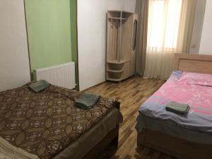 a bedroom with two beds and a television in it at Inga Jafaridze Guesthouse Pele in Mestia